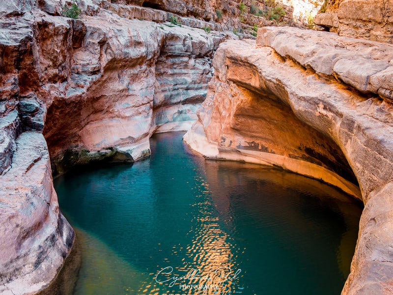 Turquoise pool between warm-coloured rock walls in Paradise Valley